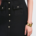 Black knitted mini skirt with silver button front detail and patch pockets, styled with gold cuff bracelet — Claudie Pierlot | Endless UAE