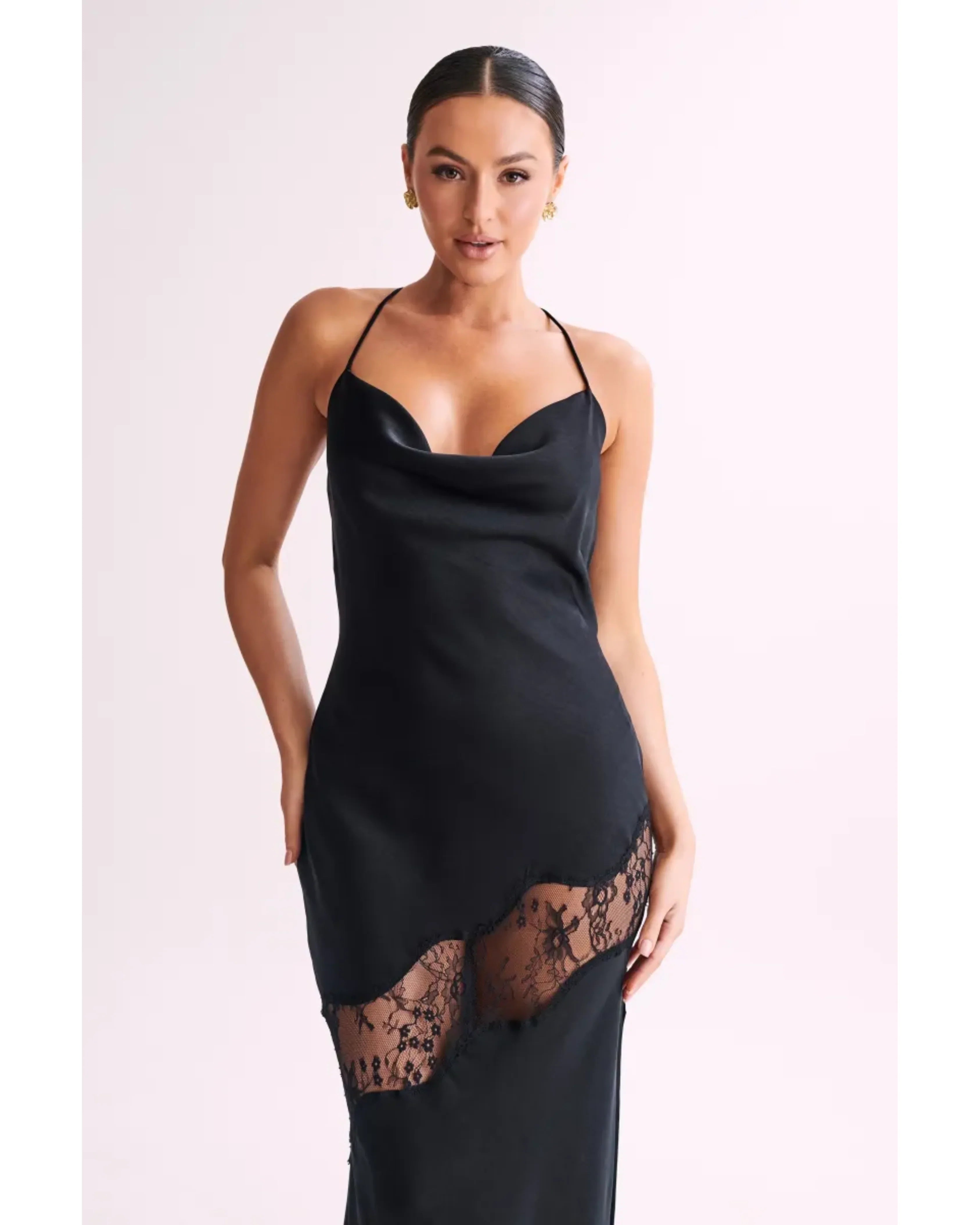 Woman wearing black satin maxi dress with lace side detail and halter neckline — Meshki | Endless UAE