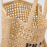 Natural woven raffia tote bag with open mesh weave design, triangle logo patch, and dual shoulder straps — Prada | Endless UAE