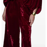 Woman wearing burgundy silk velvet jumpsuit with ornamental detailing and wide legs — Themis-Z | Endless UAE