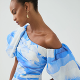 Woman wearing blue and white abstract print Cadence Ruched Midi Dress with puffed sleeves and white slides — Aje | Endless UAE