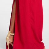 Red evening gown with dramatic side slit detail, worn with gold heels — Taller Marmo | Endless UAE
