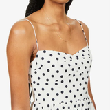 Woman wearing white organic cotton-blend midi dress with black polka dots and thin spaghetti straps — Reformation | Endless UAE