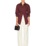 Burgundy poplin button-up shirt styled with cream trousers and black bag — Simon Miller | Endless UAE