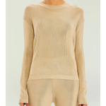 Woman wearing a beige metallic knit top and matching trousers holding a small handbag — SER.O.YA | Endless UAE