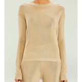 Woman wearing a beige metallic knit top and matching trousers holding a small handbag — SER.O.YA | Endless UAE