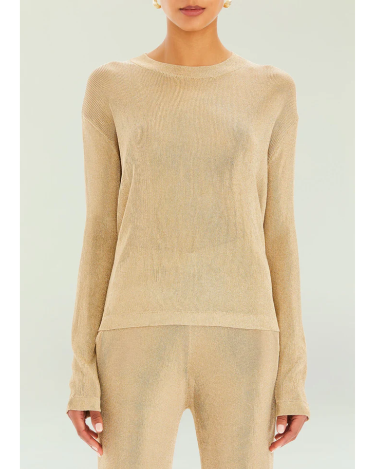 Woman wearing a beige metallic knit top and matching trousers holding a small handbag — SER.O.YA | Endless UAE