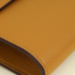 Mustard yellow Sesame Kelly To Go Evercolor wallet with dark brown trim and visible stitching detail — Hermes | Endless UAE