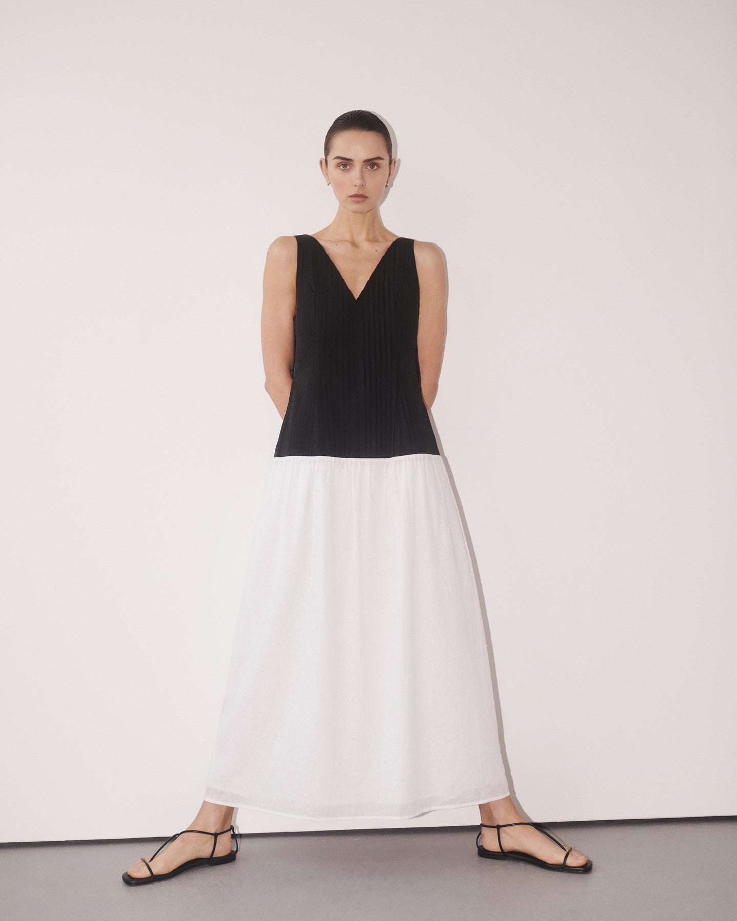 Woman wearing black and white color-block midi dress with V-neckline and black strappy sandals — DISSH | Endless UAE