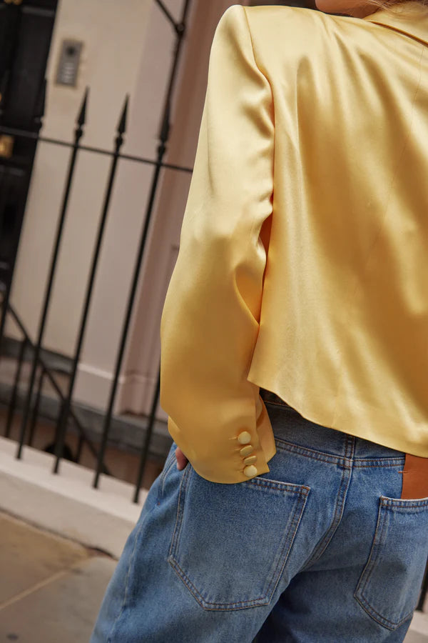 Model wearing yellow cropped silk blazer with notch lapels and blue jeans — By Keara | Endless UAE