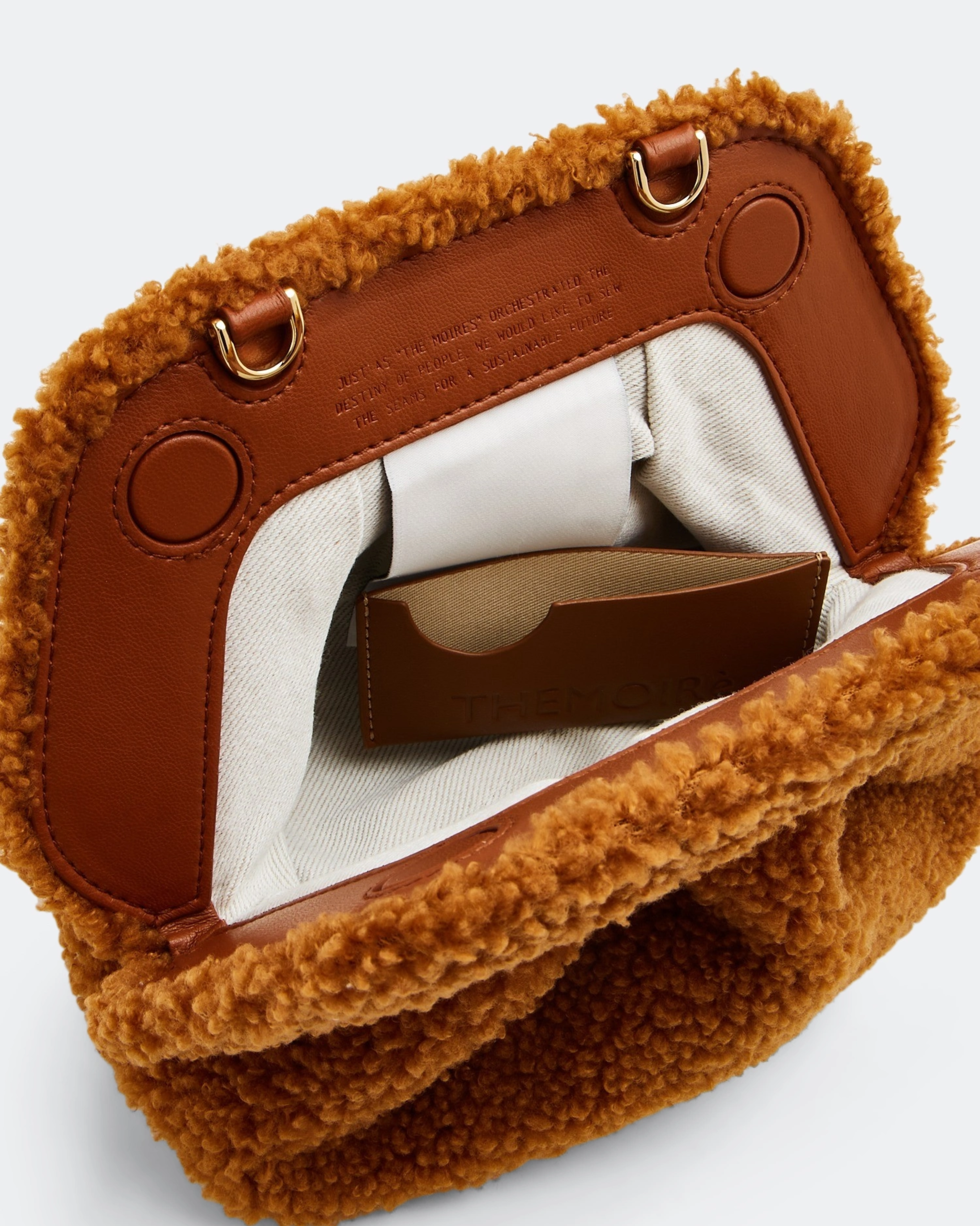 Gea Clutch in caramel brown textured fabric held in hand — TheMoire | Endless UAE