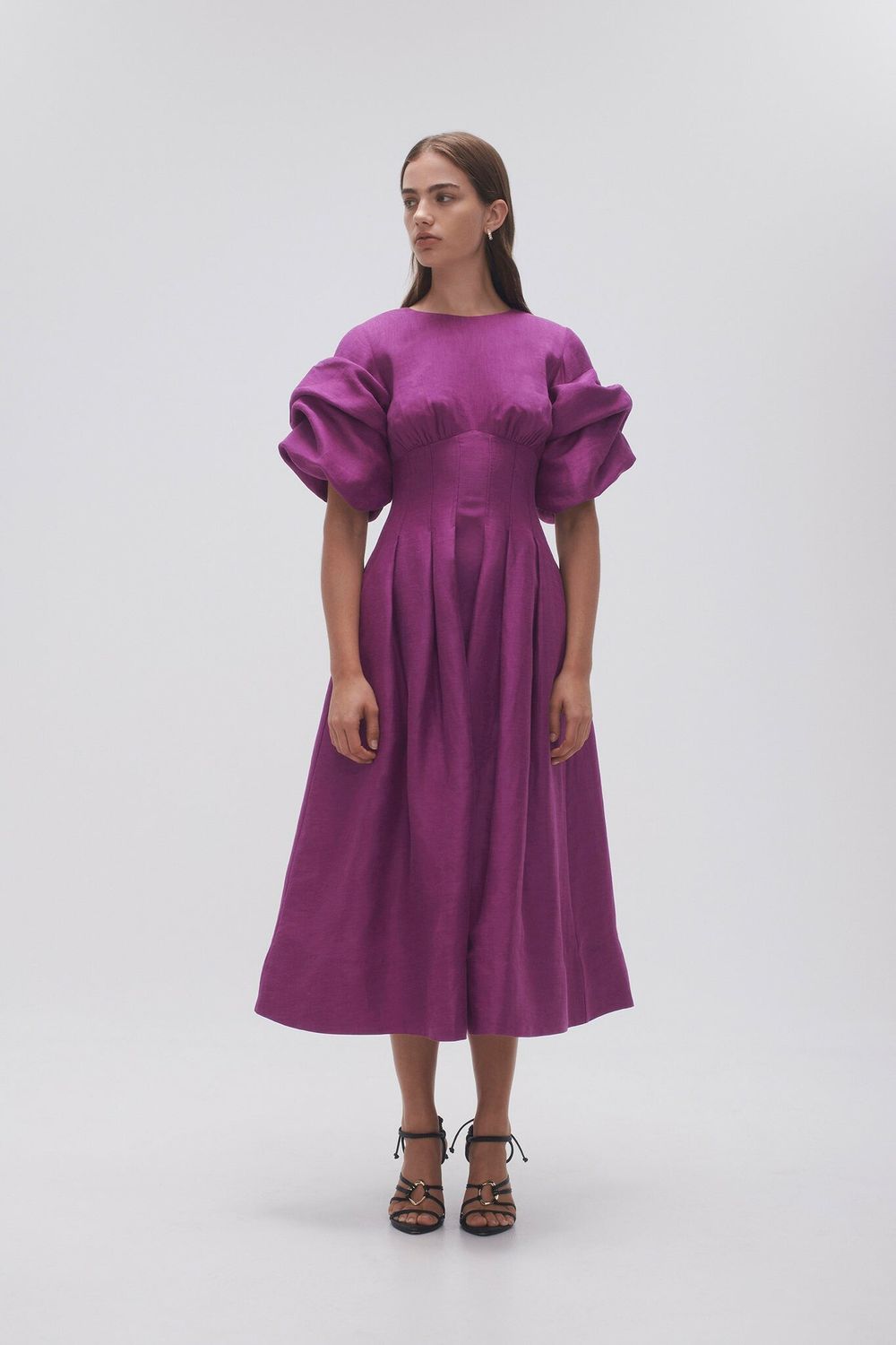 Woman wearing Adelie Puff Sleeve Midi Dress in plum with black strappy sandals — Aje | Endless UAE