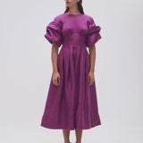 Woman wearing Adelie Puff Sleeve Midi Dress in plum with black strappy sandals — Aje | Endless UAE