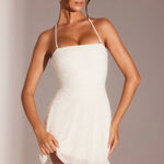 White halter A-line mini dress with embellished detail on model wearing metallic sandals — Oh Polly | Endless UAE