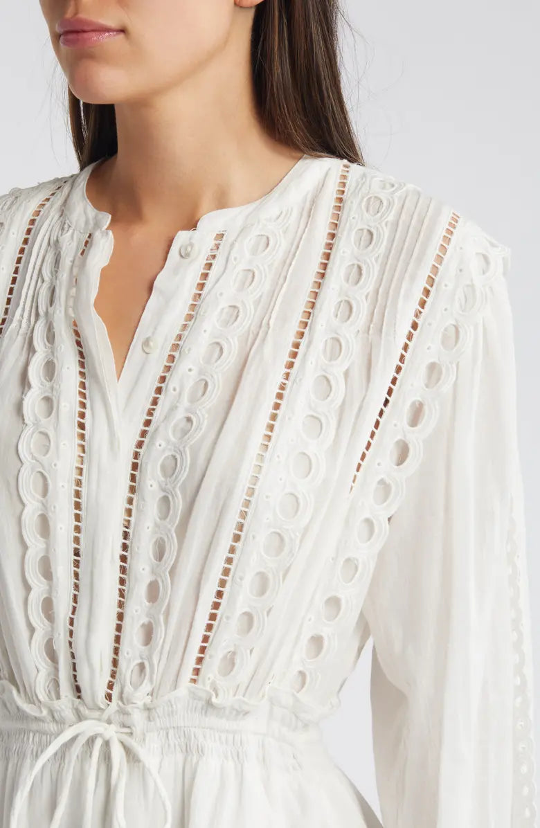 Woman wearing white eyelet cotton mini dress with long sleeves and layered skirt — LoveShackFancy | Endless UAE