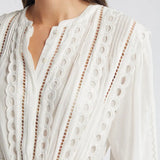 Woman wearing white eyelet cotton mini dress with long sleeves and layered skirt — LoveShackFancy | Endless UAE