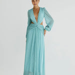 Woman wearing a flowing light blue wrap dress with long sleeves and cutout waist detail — Anne Louise Boutique | Endless UAE