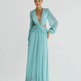 Woman wearing a flowing light blue wrap dress with long sleeves and cutout waist detail — Anne Louise Boutique | Endless UAE