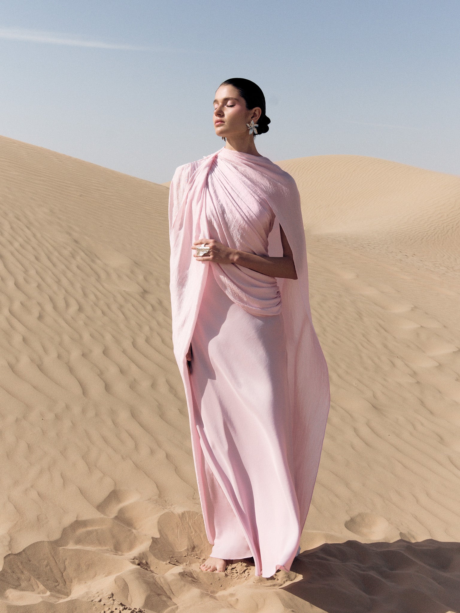Woman wearing pink textured maxi dress in desert setting — Lichi | Endless UAE