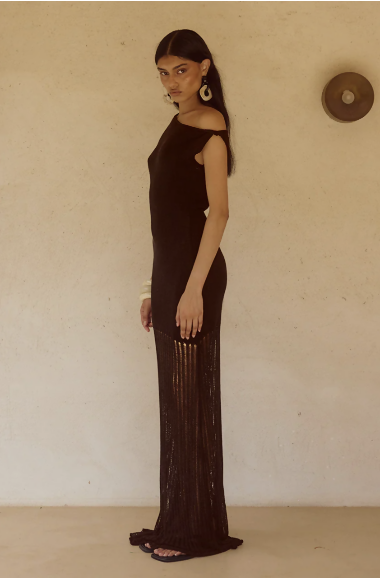 Woman wearing black off-shoulder knit maxi dress with fringe hem and white bangles — Endless | Endless UAE