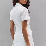 White collared mini dress with short sleeves and pleated hem worn by model — Amanda Uprichard | Endless UAE