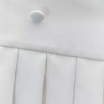 White mini dress with pleated skirt and button detail on white background — Amanda Uprichard | Endless UAE