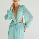 Woman wearing a flowing light blue wrap dress with long sleeves and cutout waist detail — Anne Louise Boutique | Endless UAE