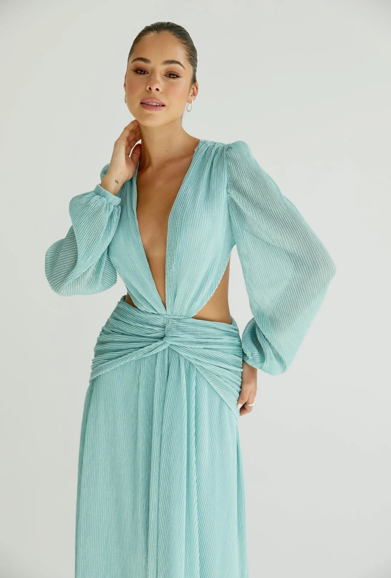 Woman wearing a flowing light blue wrap dress with long sleeves and cutout waist detail — Anne Louise Boutique | Endless UAE