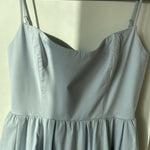 Woman wearing light blue sleeveless midi dress with corset top and full skirt — Endless | Endless UAE