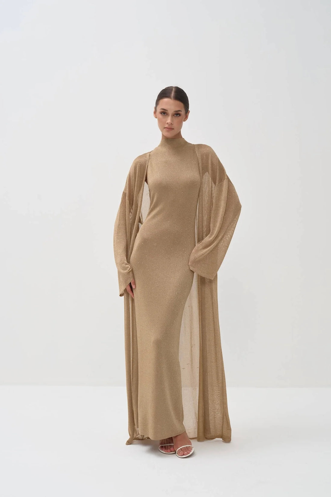 Elegant gold shimmer maxi dress with matching long cardigan, turtleneck design and flowing silhouette — Nora The Label | Endless UAE