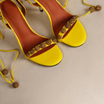 Bright yellow strappy heels with gold glitter embellishments and ankle ties — Subashini Heels | Endless UAE