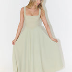 Woman wearing sage green square neck midi dress with full skirt and pockets — Odd Muse | Endless UAE