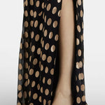 Black polka-dot maxi dress with one-shoulder design and flowing silhouette paired with gold metallic sandals — Alexandra Miro | Endless UAE