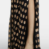 Black polka-dot maxi dress with one-shoulder design and flowing silhouette paired with gold metallic sandals — Alexandra Miro | Endless UAE