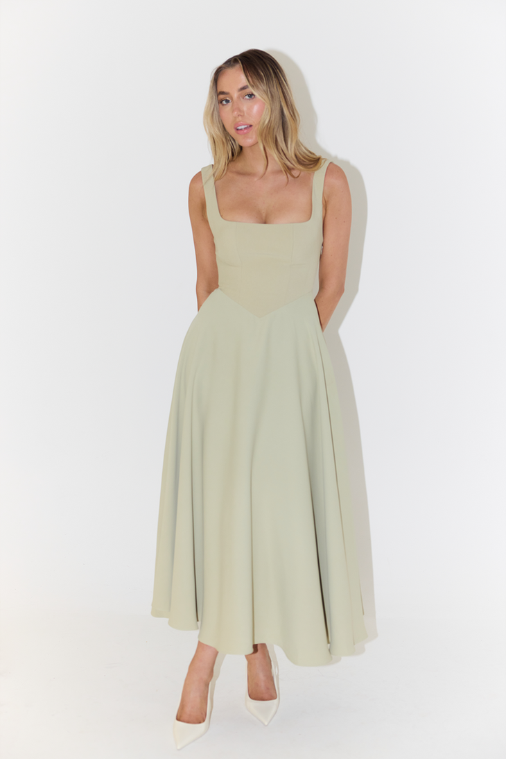 Woman wearing cream square neck midi dress with flowing skirt and white heels — Odd Muse | Endless UAE