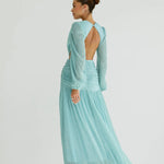 Woman wearing a flowing light blue wrap dress with long sleeves and cutout waist detail — Anne Louise Boutique | Endless UAE