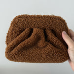 Gea Clutch in caramel brown textured fabric held in hand — TheMoire | Endless UAE