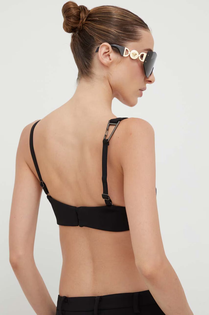 Woman wearing black cut-out co-ord set with strappy back detail and sunglasses, hair in bun — Patrizia Pepe | Endless UAE