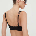 Woman wearing black cut-out co-ord set with strappy back detail and sunglasses, hair in bun — Patrizia Pepe | Endless UAE
