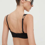 Woman wearing black cut-out co-ord set with strappy back detail and sunglasses, hair in bun — Patrizia Pepe | Endless UAE