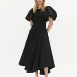 Woman wearing black Wisteria Cotton Midi Dress with puffed sleeves and asymmetrical hem — Aje | Endless UAE