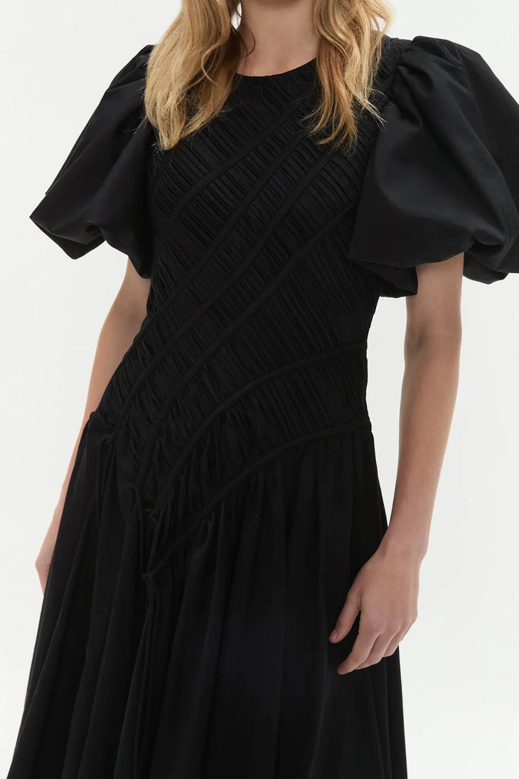 Woman wearing black Wisteria Cotton Midi Dress with puffed sleeves and asymmetrical hem — Aje | Endless UAE