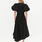 Woman wearing black Wisteria Cotton Midi Dress with puffed sleeves and asymmetrical hem — Aje | Endless UAE
