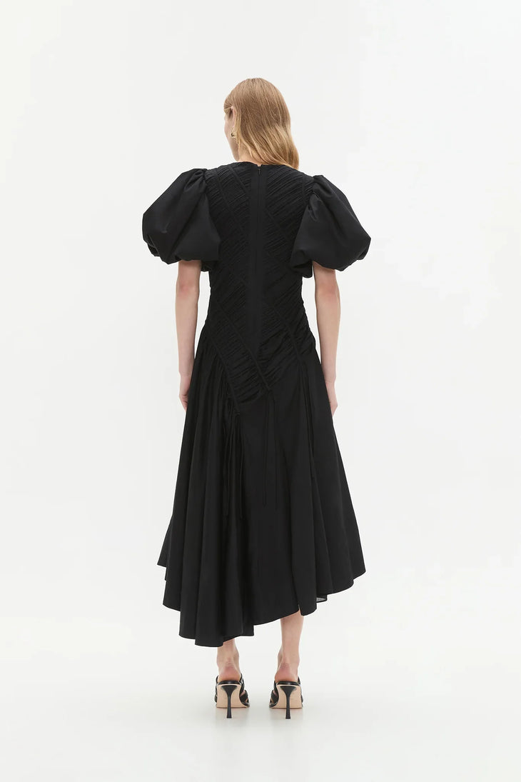Woman wearing black Wisteria Cotton Midi Dress with puffed sleeves and asymmetrical hem — Aje | Endless UAE