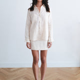 Woman wearing cream linen button-up shirt and mini skirt set with black heels — Amara Grace | Endless UAE