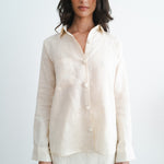 Woman wearing cream linen button-up shirt and matching mini skirt set against white background — Amara Grace | Endless UAE