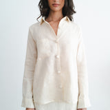 Woman wearing cream linen button-up shirt and matching mini skirt set against white background — Amara Grace | Endless UAE