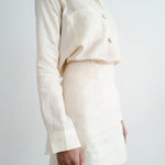Woman wearing cream linen shirt and shorts set in relaxed fit with chest pocket and button front — Amara Grace | Endless UAE