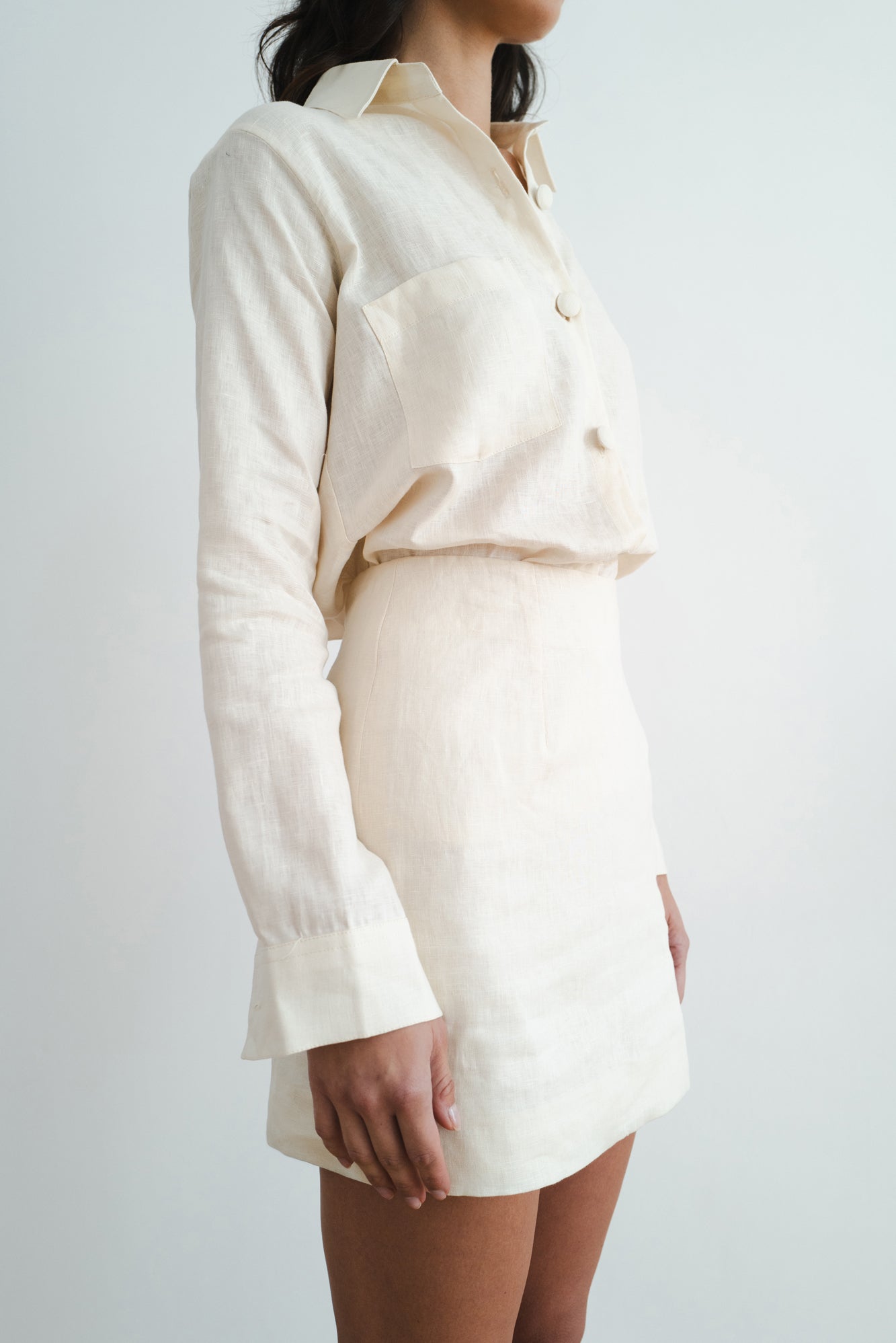 Woman wearing cream linen shirt and shorts set in relaxed fit with chest pocket and button front — Amara Grace | Endless UAE
