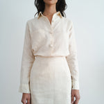Woman wearing cream linen button-up shirt and matching mini skirt set against white background — Amara Grace | Endless UAE